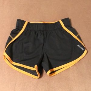 NWOT Reebok Speedwick athletic dolphin hem shorts. Orange and gray. Size XS.